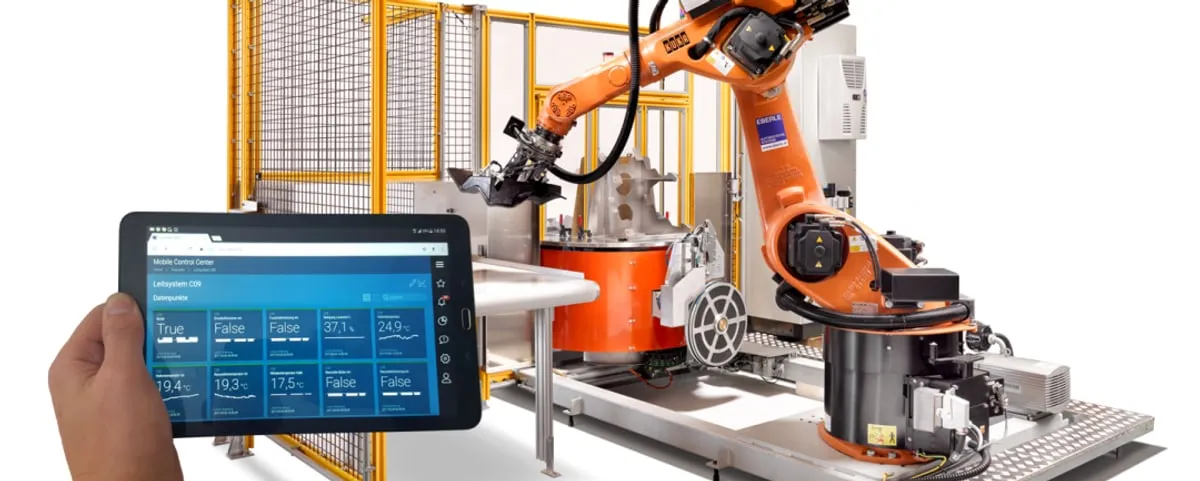 control monitoring on a tablet in front of a robot cell — data tiles with live process values