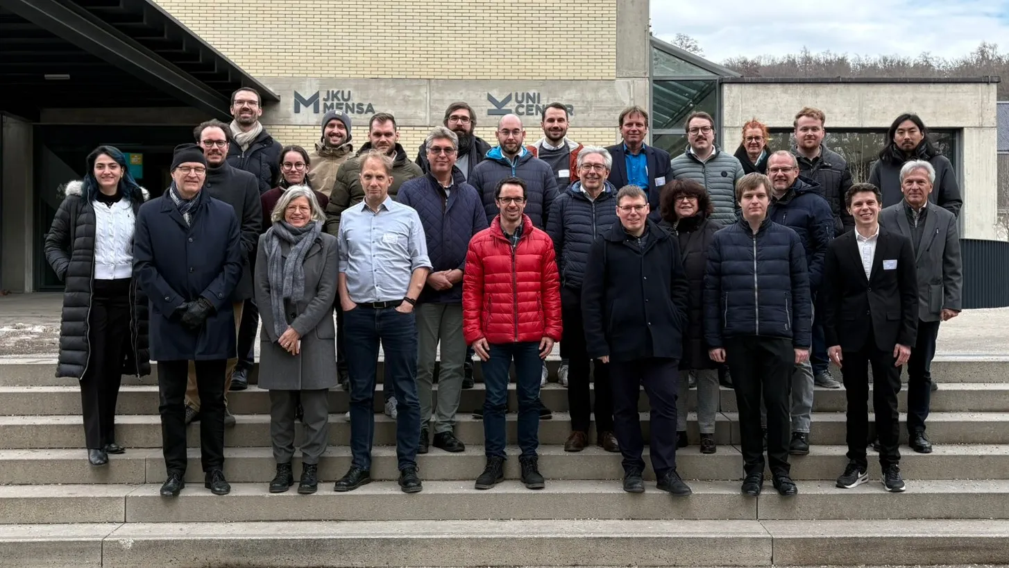 Group photo of the MetaLin-X project partners on the steps in front of the JKU cafeteria in Linz