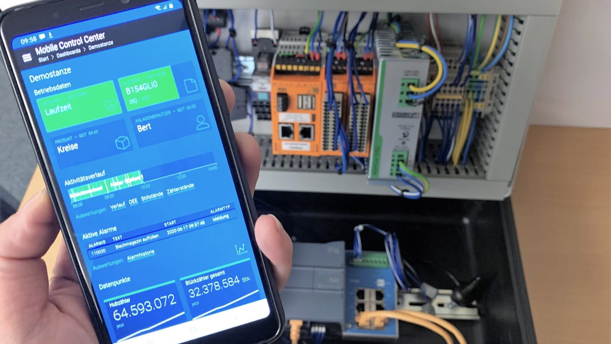 control BDE am Smartphone vor einem geöffneten Schaltschrank — Betriebsdaten, Auftrag und Zählerstände